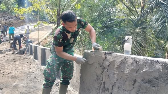 Satgas TMMD dan Warga Giri Madia Bangun Sayap Jembatan
