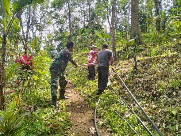 Wujud Kepedulian TNI, Babinsa Kawal Pelepasan Pipa Irigasi Subak di Panji Anom